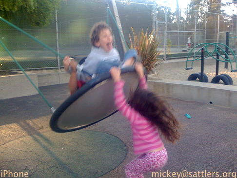 Lila pushes Isaac on a swing at Julias Kahn playground