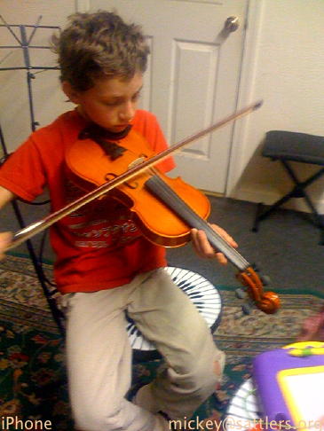 Isaac tries the violin